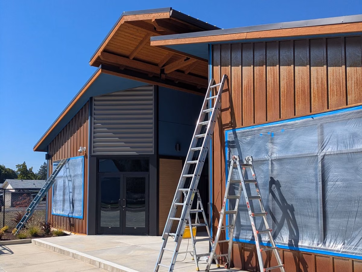 Commercial building with windows masked and ladders set up for painting