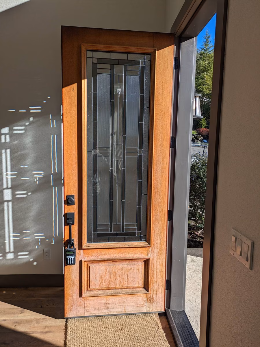 Wood front door with a faded, worn finish before refinishing