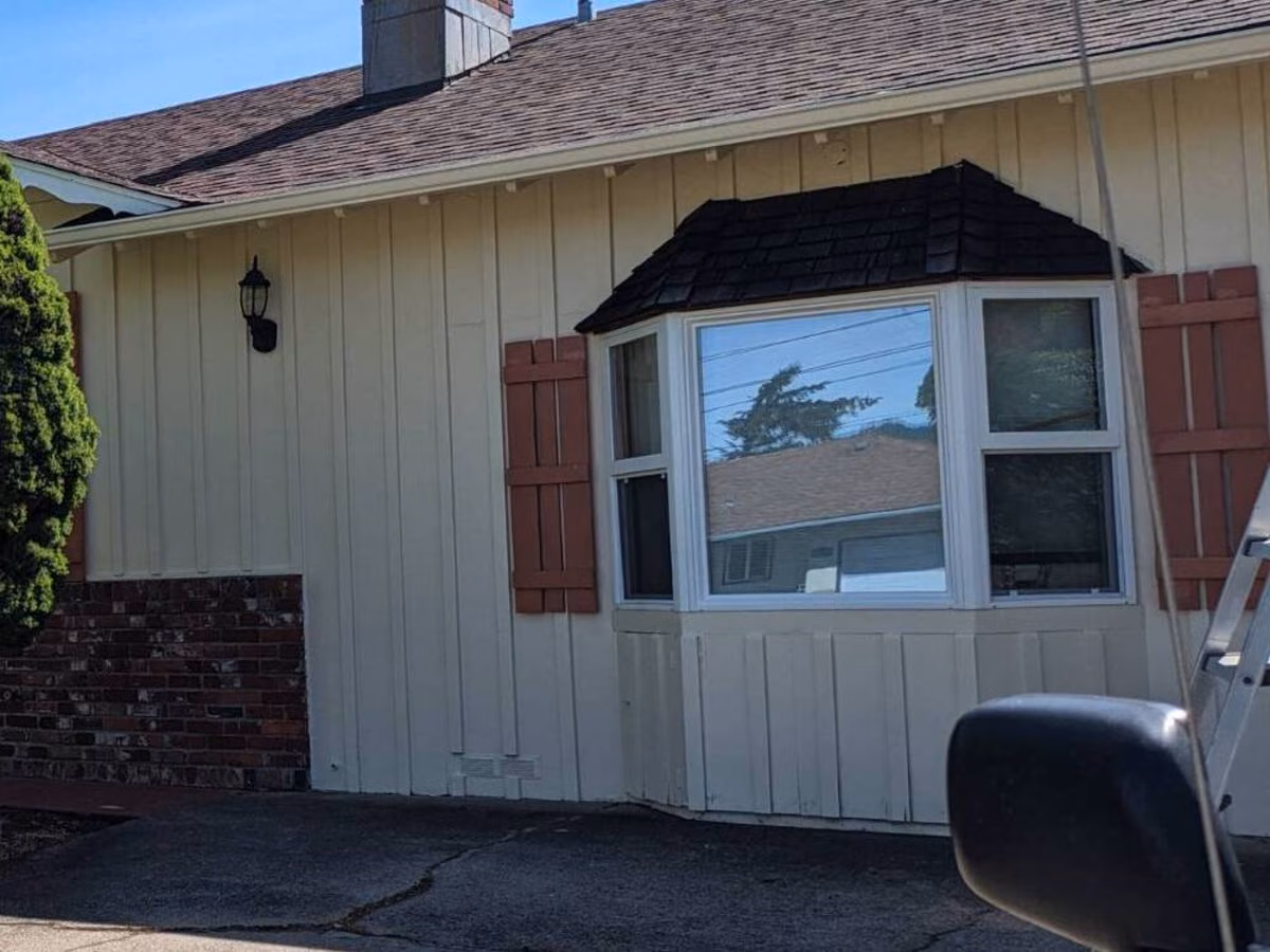 Front of the same ranch home after painting, with terracotta shutters